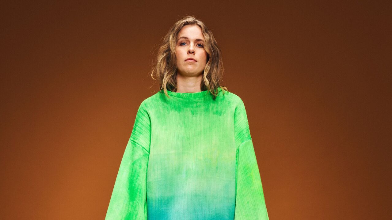 Myrte Siebinga in een grote groene trui