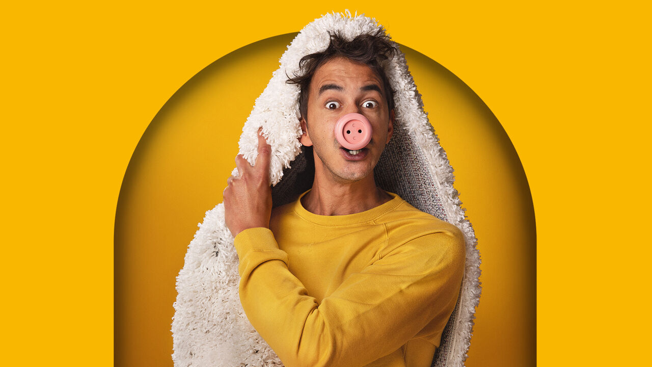 Acteur met een varkensneus en een lammetjesdeken om