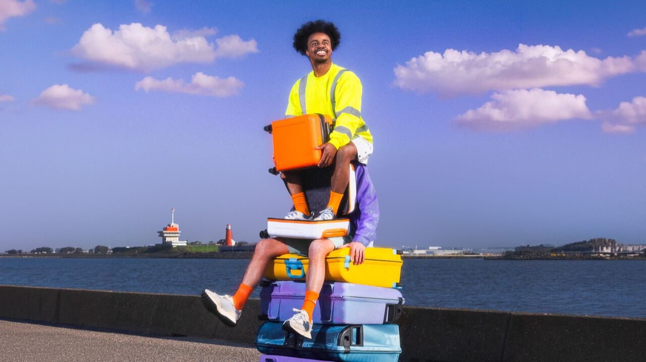 Twee acteurs zitten op een stapel koffers
