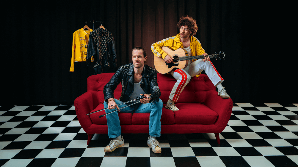 Twee muzikanten maken muziek op een rode bank