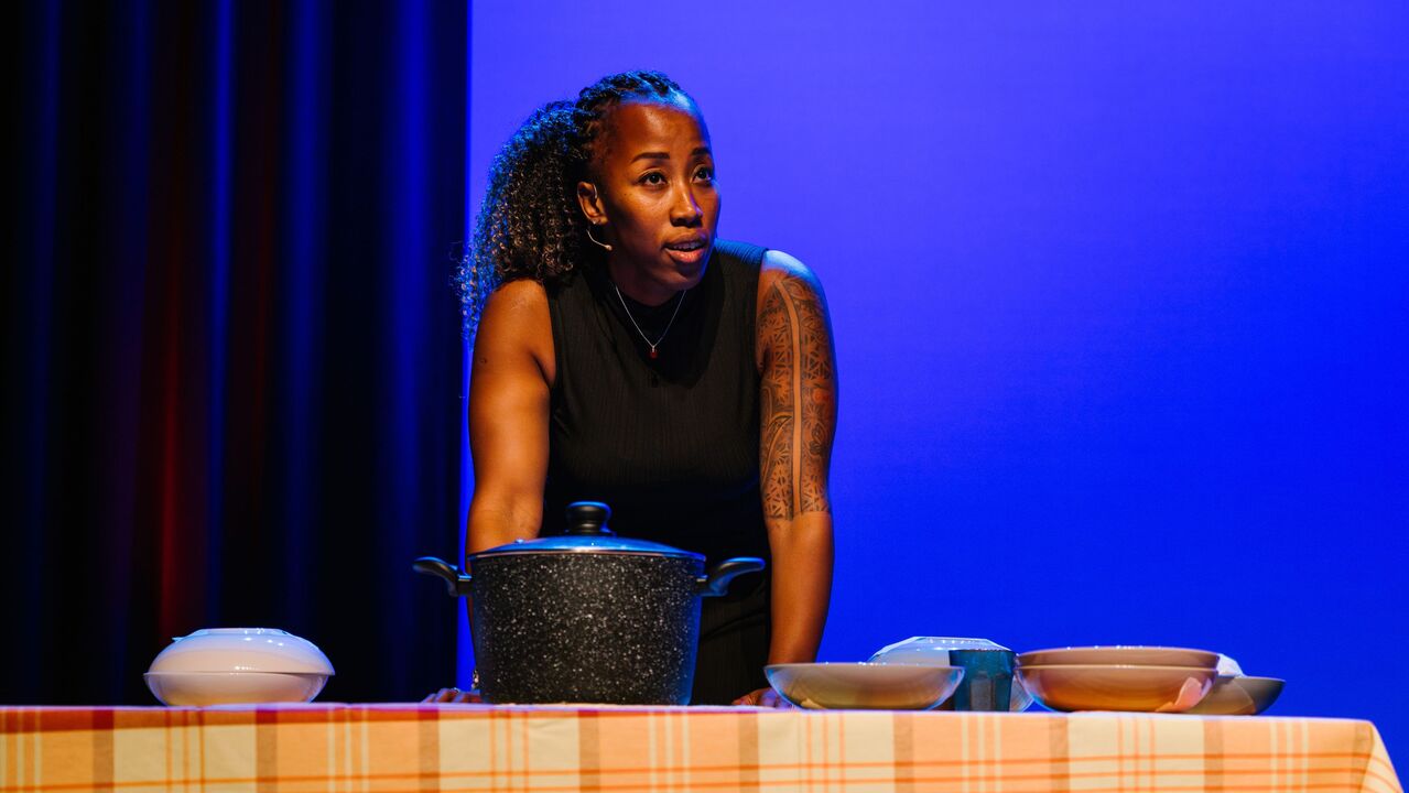 Betty Loha staat bij een tafel met een pan en borden